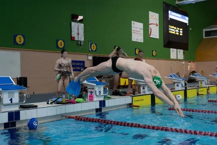 Ryan diving in from the poolside at the start of a training set.